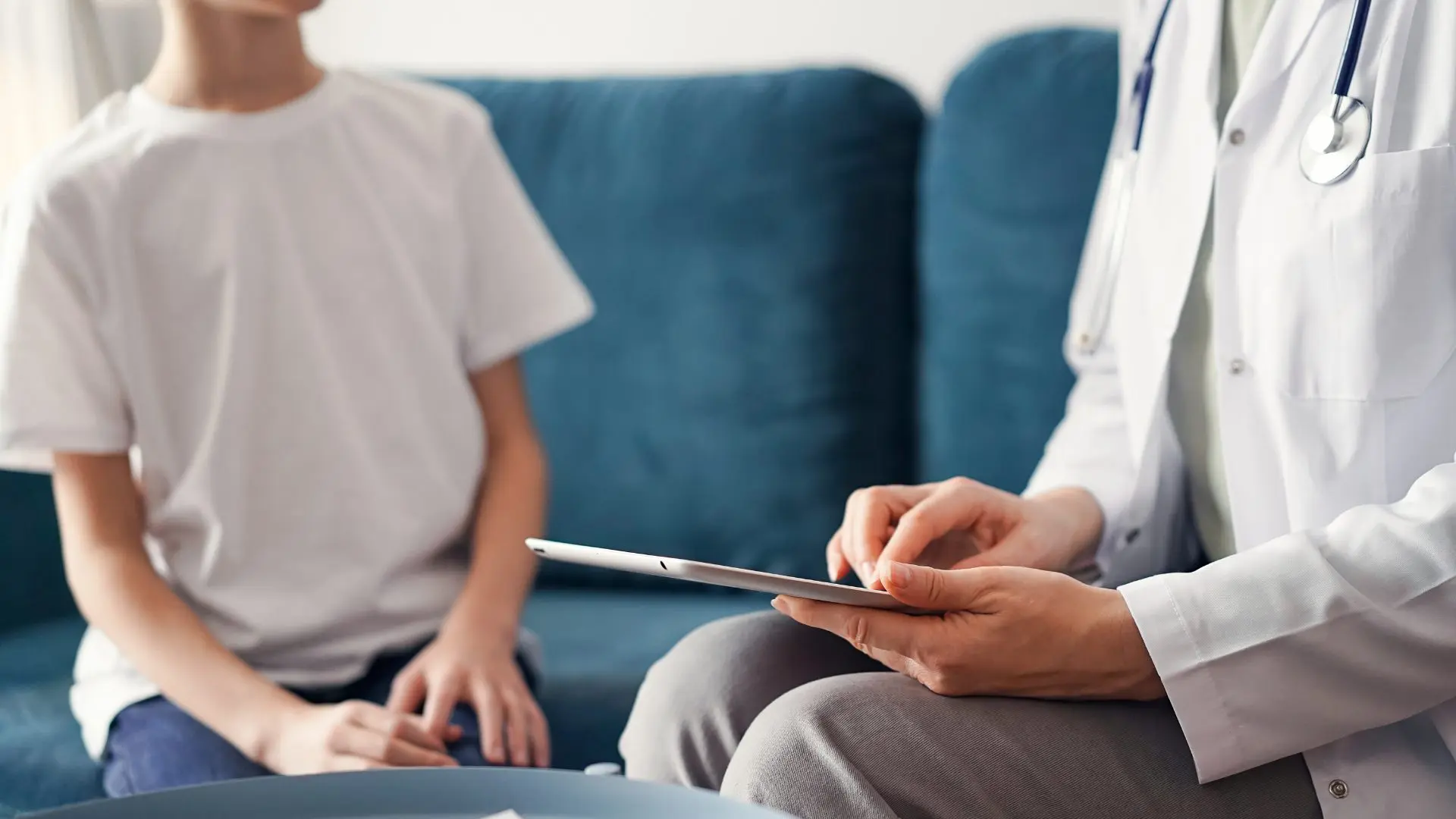 Stock Photo ID: 2262066589 Doctor woman and kid boy patient at home. The pediatrician using tablet computer while filling up medical records, close up. Medicine, healthcare concepts.